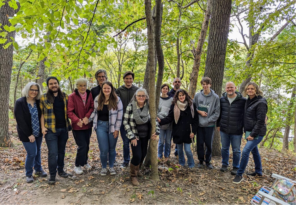 A portrait of a multigenerational family smiling after a nature memorial ceremony in the memorial forest.